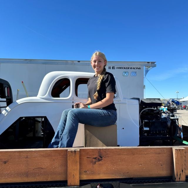 Kaylee Decker in the bed of her truck sitting next to the 10,000th chassis after pick up on November 6.